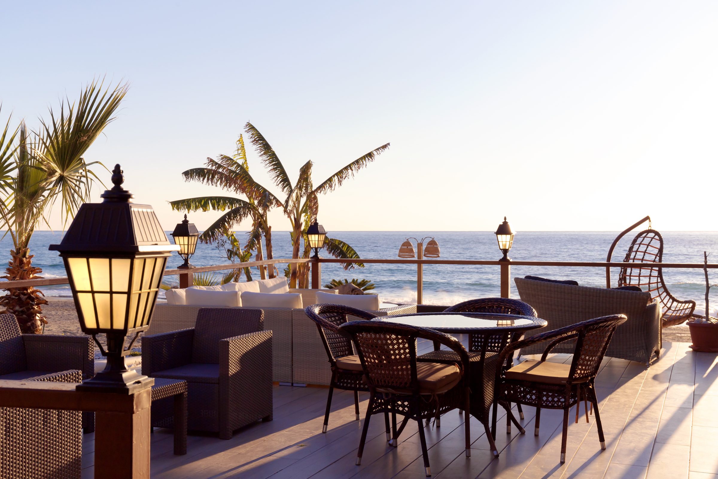 Restaurant terrace overlooking the sea at sunset.